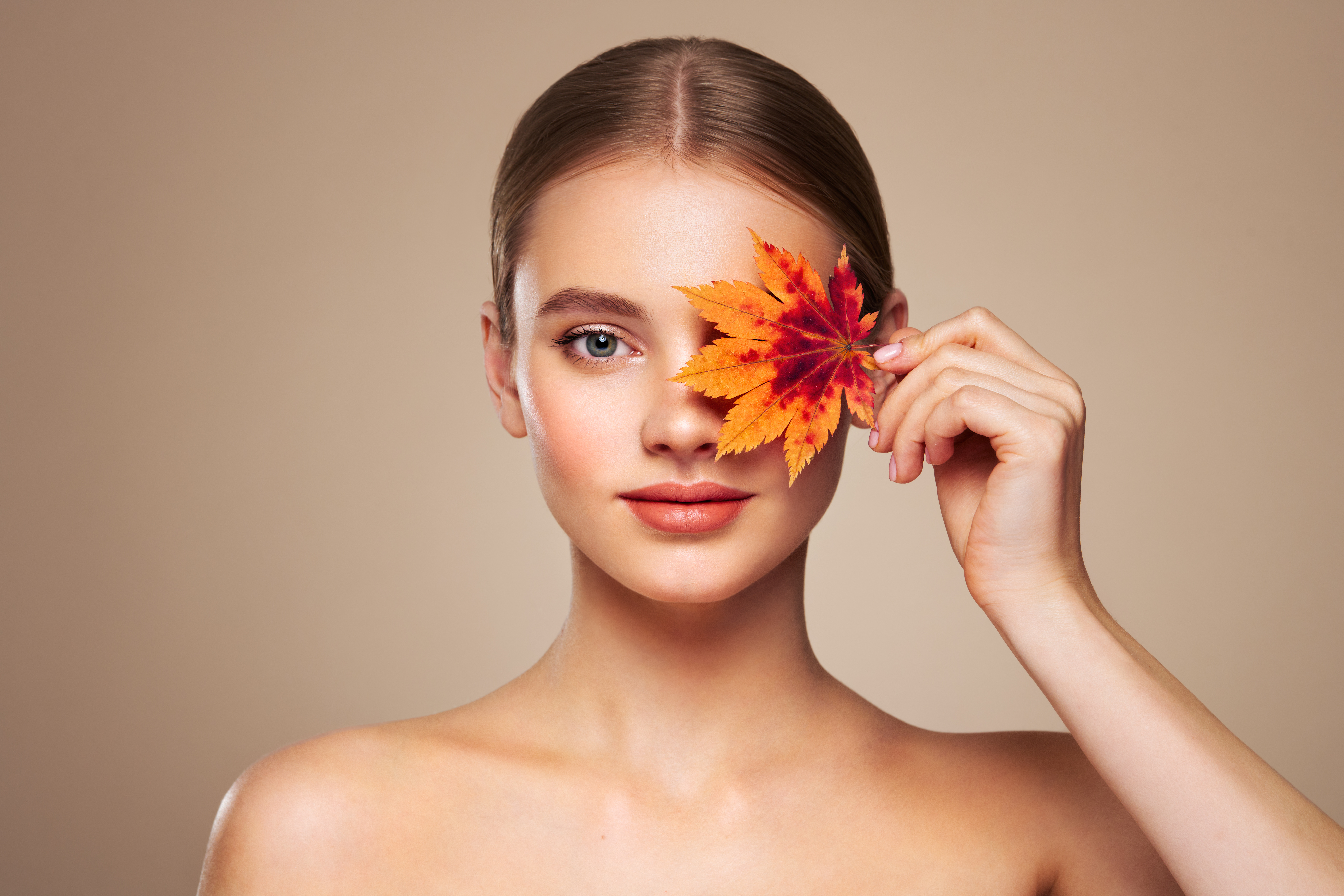 Portrait of beautiful young woman with autumn leafs. Healthy clean fresh skin natural make up beauty eyes Portrait of beautiful young woman with autumn leafs. Healthy clean fresh skin natural make up beauty eyes